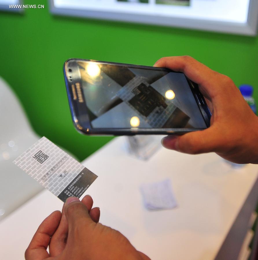 An exhibitor uses a smartphone application to present the 3D effect of a business card at the International Design Expo in Beijing, capital of China, May 30, 2013. Opened Thursday, the expo is part of the 2013 China Design Festival from May 30 to June 1 in Beijing's Daxing District. (Xinhua/He Canling) 