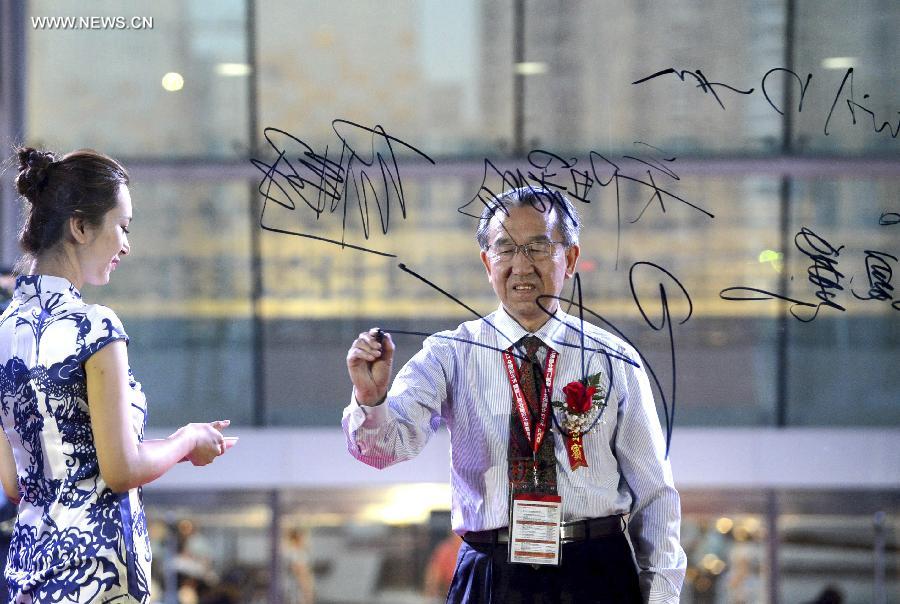 Lu Changde, professor of Northwestern Polytechnical University and winner of China Design Contribution Golden Medal, signs name at the China Design Festival in Beijing, capital of China, May 29, 2013. The China Design Festival, which kicked off on May 30, will last until June 1. (Xinhua) 