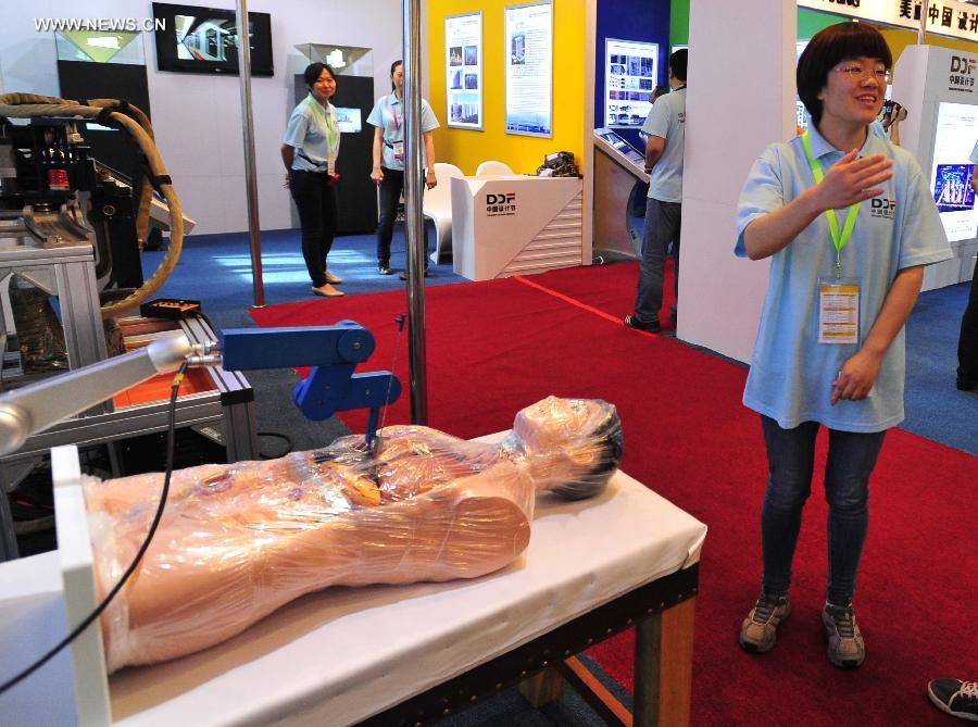 An exhibitor introduces a robot system for liver tumor treatment at the International Design Expo in Beijing, capital of China, May 30, 2013. Opened Thursday, the expo is part of the 2013 China Design Festival from May 30 to June 1 Beijing's Daxing District. (Xinhua/He Canling) 
