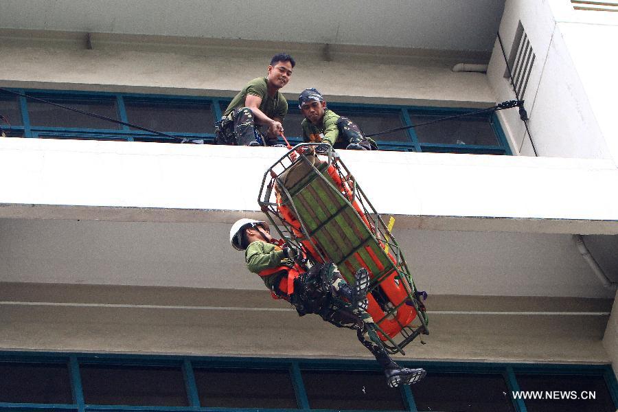 Armed Forces of the Philippines (AFP) soldiers rappel a mock victim down a building during a rescue drill in Quezon City, the Philippines, May 31, 2013. (Xinhua/Rouelle Umali) 