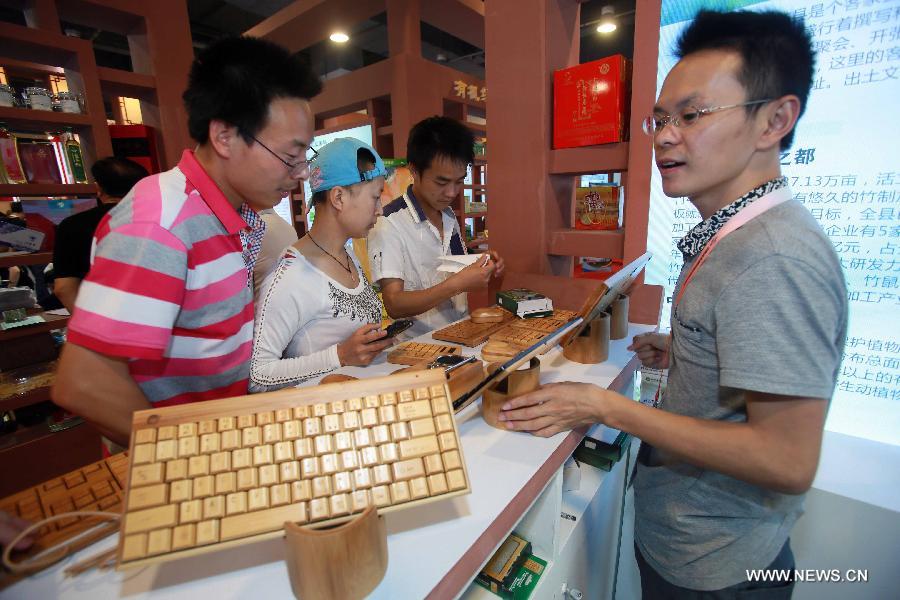Visitors watch bamboo-made electronic products at China Beijing International Fair for Trade in Services (Beijing Fair) in Beijing, capital of China, May 31, 2013. (Xinhua/Chen Jingsu)  