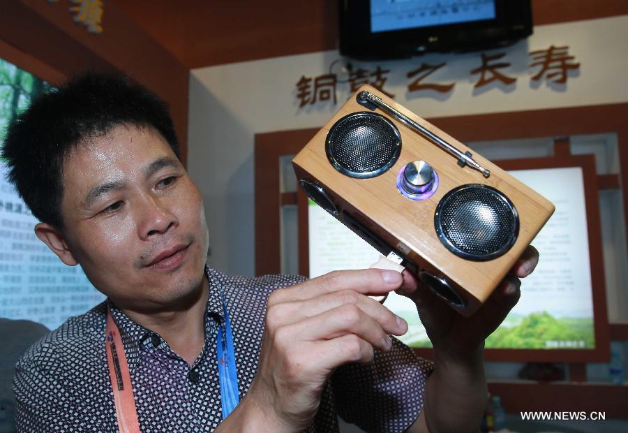 A staff member inserts a flash disk into a bamboo-made music player at China Beijing International Fair for Trade in Services (Beijing Fair) in Beijing, capital of China, May 31, 2013. (Xinhua/Chen Jingsu)  