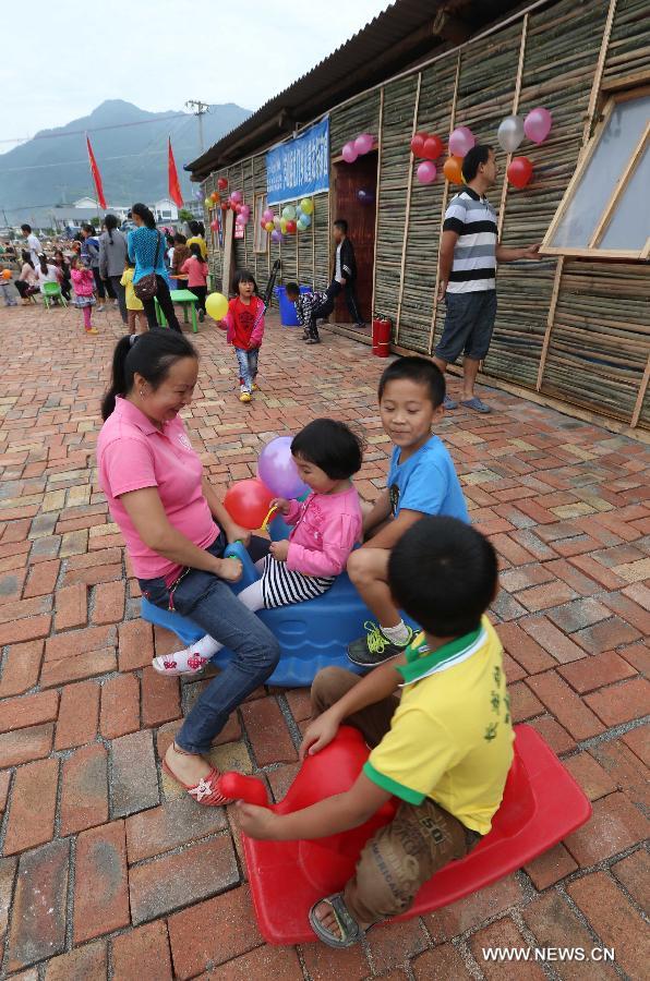 Children and their parents play games at a children's park near makeshift houses in Longmen Township of Lushan County in Ya'an City, southwest China's Sichuan Province, June 1, 2013. Children in Lushan, which was severely hit by a 7.0-magnitude earthquake on April 20, 2013, spent their children's day here in makeshift houses on Saturday. (Xinhua/Liu Yinghua) 