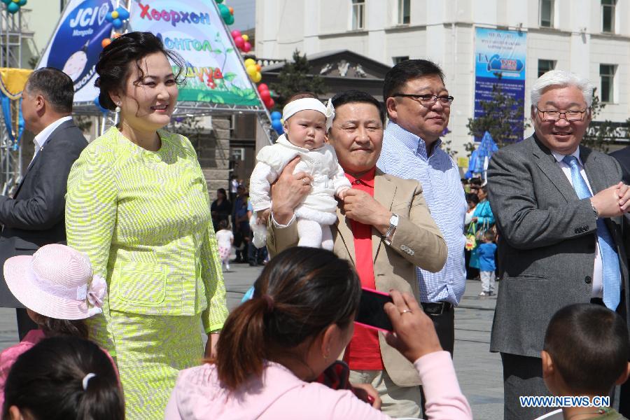 Mongolia's Prime Minister Altankhuyag Norov (C) attends a celebration with his wife and his child during the International Children's Day in Ulan Bator, Mongolia, June 1, 2013. (Xinhua/Shi Yongchun)