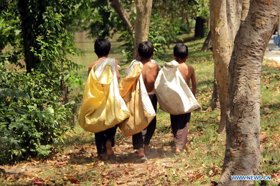 Pakistani children carry sacks of garbage as they return to their homes on International Children's Day in eastern Pakistan's Lahore, June 1, 2013. The International Children's Day was observed in the country on Saturday, with non-governmental organizations and schools promoting international fraternity and harmony among children from different backgrounds, as well as equal rights for every child. (Xinhua/Jamil Ahmed)