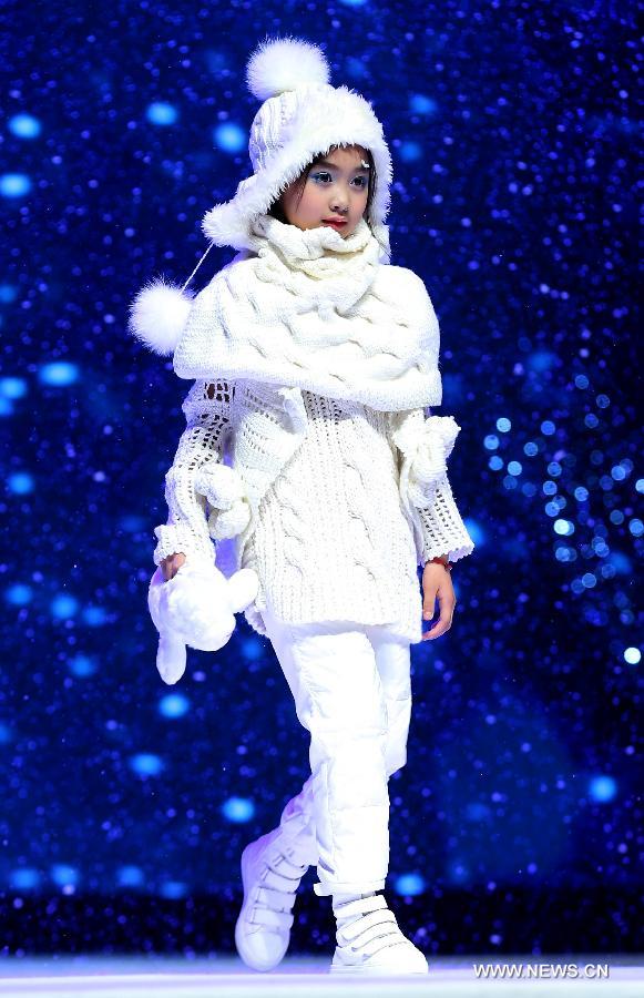 A child presents a creation of children's wear during the final of the first China (Zhili) National Children's Wear Design Contest in Huzhou City, east China's Zhejiang Province, June 1, 2013. Zhili Town, located in the Wuxing District of Huzhou City, is famous for its children's wear. (Xinhua/Chen Jianli)