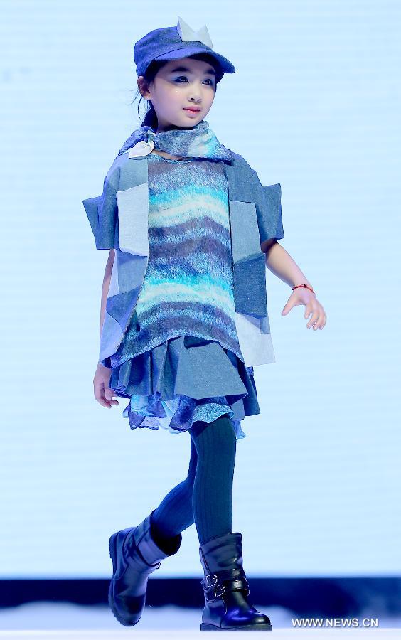 A child presents a creation of children's wear during the final of the first China (Zhili) National Children's Wear Design Contest in Huzhou City, east China's Zhejiang Province, June 1, 2013. Zhili Town, located in the Wuxing District of Huzhou City, is famous for its children's wear. (Xinhua/Chen Jianli)