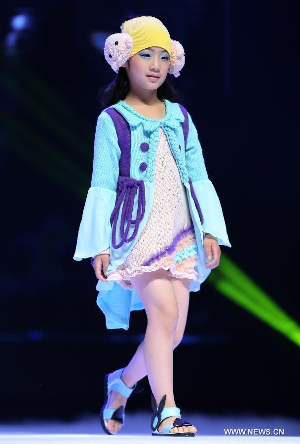 A child presents a creation of children's wear during the final of the first China (Zhili) National Children's Wear Design Contest in Huzhou City, east China's Zhejiang Province, June 1, 2013. Zhili Town, located in the Wuxing District of Huzhou City, is famous for its children's wear. (Xinhua/Chen Jianli)