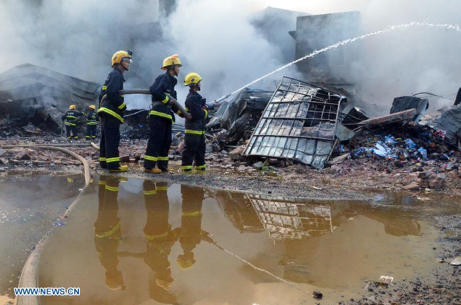 Firemen spray water at the scene of a fire at Daxin Village in Yulin City, south China's Guangxi Zhuang Autonomous Region, early June 2, 2013. The fire broke out at a storehouse early Sunday and was put out after hours by local fire department. The fire burned an area of some 3,000 square meters, with no casualties reported. (Xinhua/Wei Gongbing)