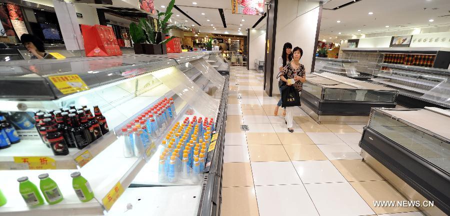 A customer walks beside shelves on which few beverage is left at the Japan-based Isetan Supermarket in Shenyang, capital of northeast China's Liaoning Province, May 31, 2013. Isetan Mitsukoshi Holdings Ltd. closed its department store in Shenyang on June 1, 2013 amid poor business conditions. Earlier, Isetan Mitsukoshi closed other two stores respectively in east China's Shanghai and Jinan. (Xinhua/Yao Jianfeng)  