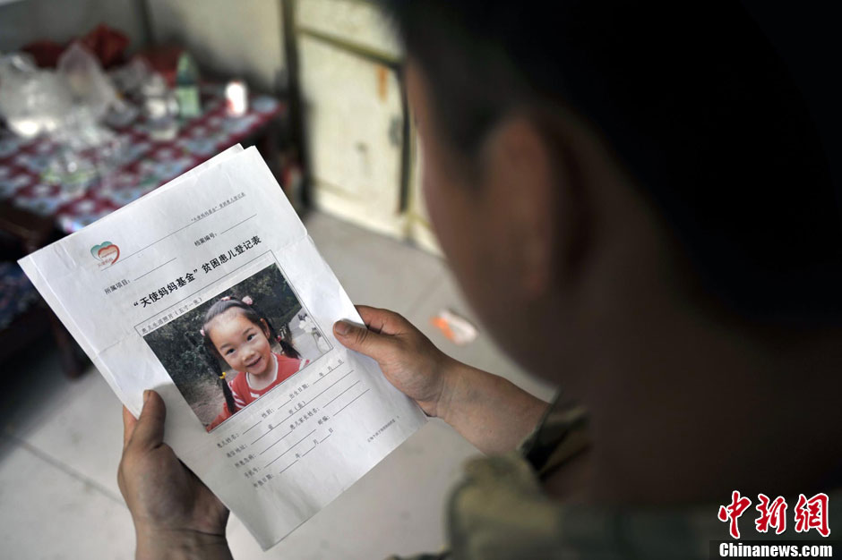 Cao's father watches the photo of her taken before the accident. (Photo/Chinanews)