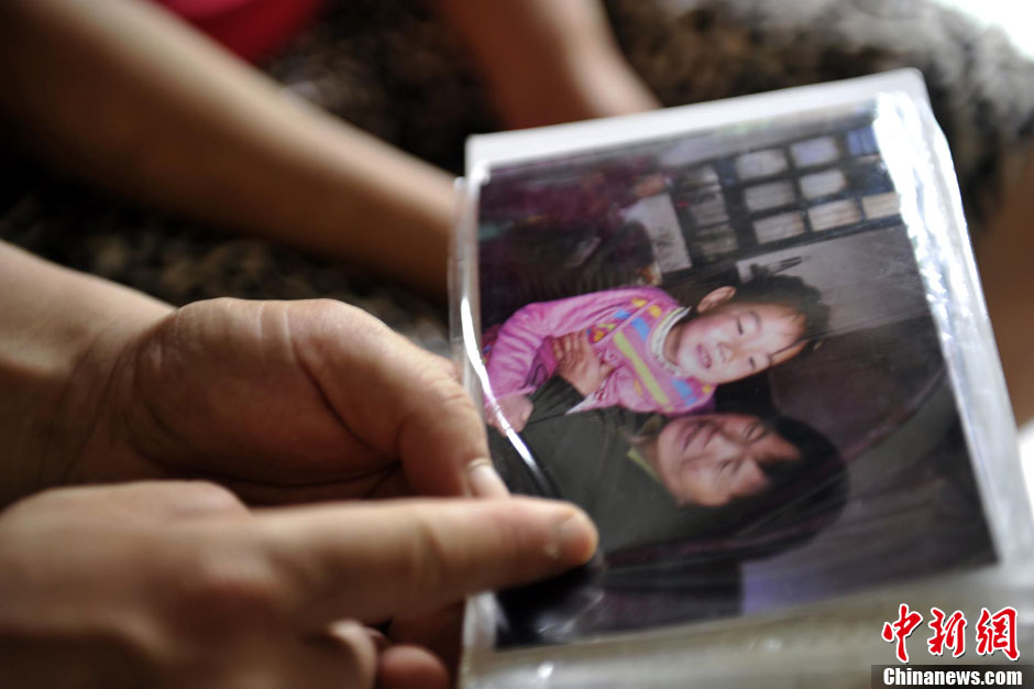 Cao's parents look at the photo of her and her grandmother taken before the accident. (Photo/Chinanews)