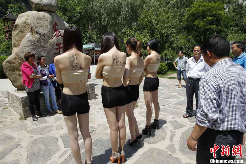 Four women hold boards with words demanding for a special place where the tourists can sign their signitures at will in Yangzigou scenic spot, in centeral China's Henan Province, June 2, 2013. (Source: chinanews.com) 