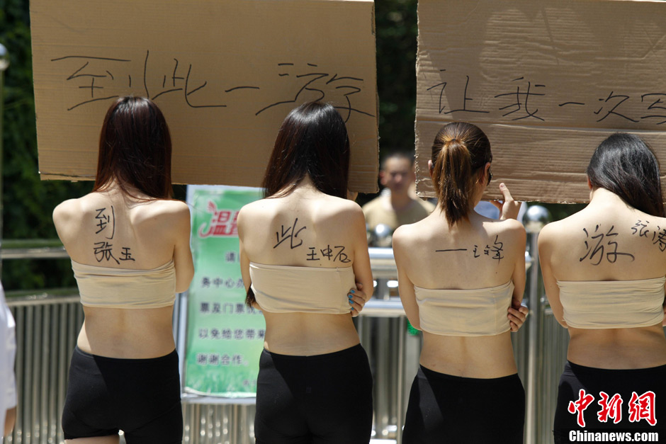 Four women hold boardswith words demanding for a special place where the tourists can sign their signitures at will in Yangzigou scenic spot, in centeral China's Henan Province, June 2, 2013. (Source: chinanews.com) 