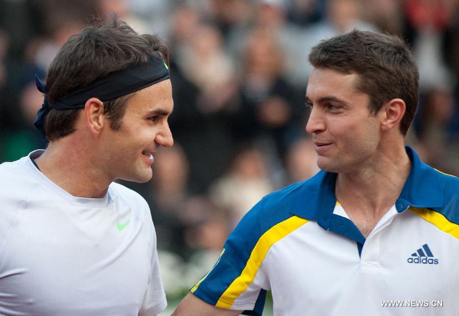 Roger Federer (L) of Switzerland and Gilles Simon of France greet each other after their men's singles fourth round match on day 8 of the 2013 French Open tennis tournament at Roland Garros in Paris, France, on June 2, 2013. Roger Federer won 3-2 to enter the quarter-finals. (Xinhua/Bai Xue)