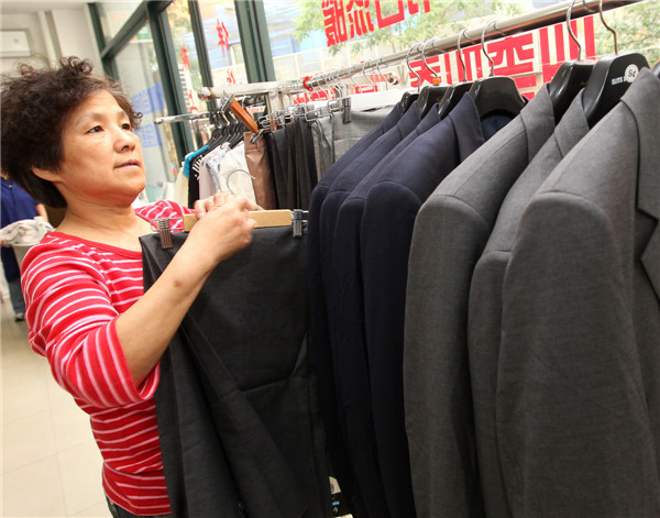 A volunteer in the charity store arranges the donated clothes in Shanghai, June 2, 2013. The store is the city's first community charity store, selling daily necessities as well as used clothes donated by residents capped at 50 yuan. The store receives more than 50,000 donated clothes a year from around 120 local residents a month. All the revenue is donated to charity organizations to help more people in need. 