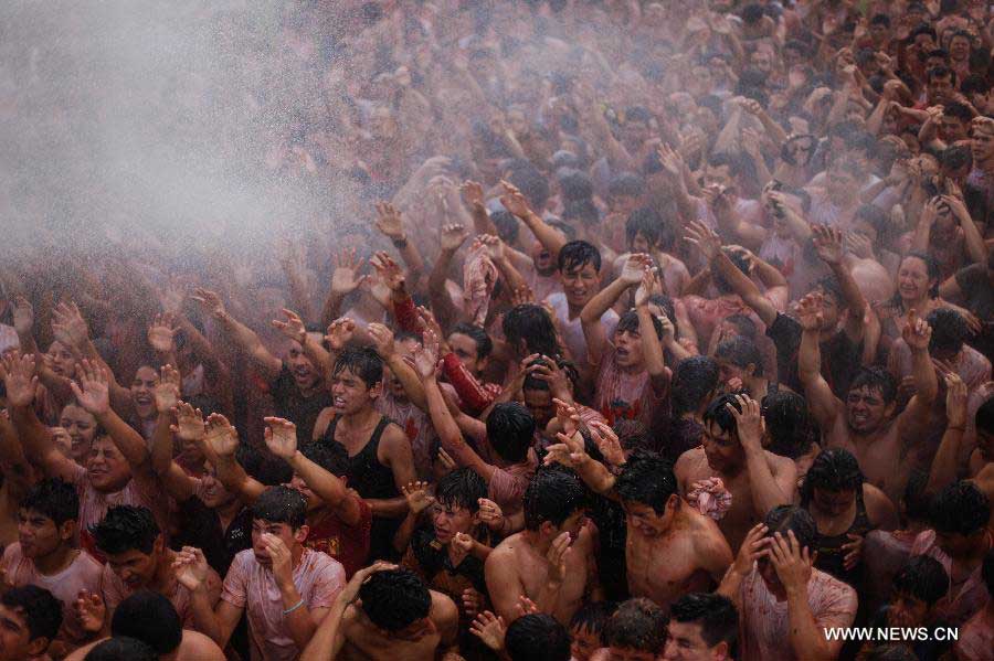 Revellers take part in the annual tomato fight called "Tomatina", in Sutamarchan municipality, Bocoya department, Colombia, on June 2, 2013. (Xinhua/Jhon Paz) 