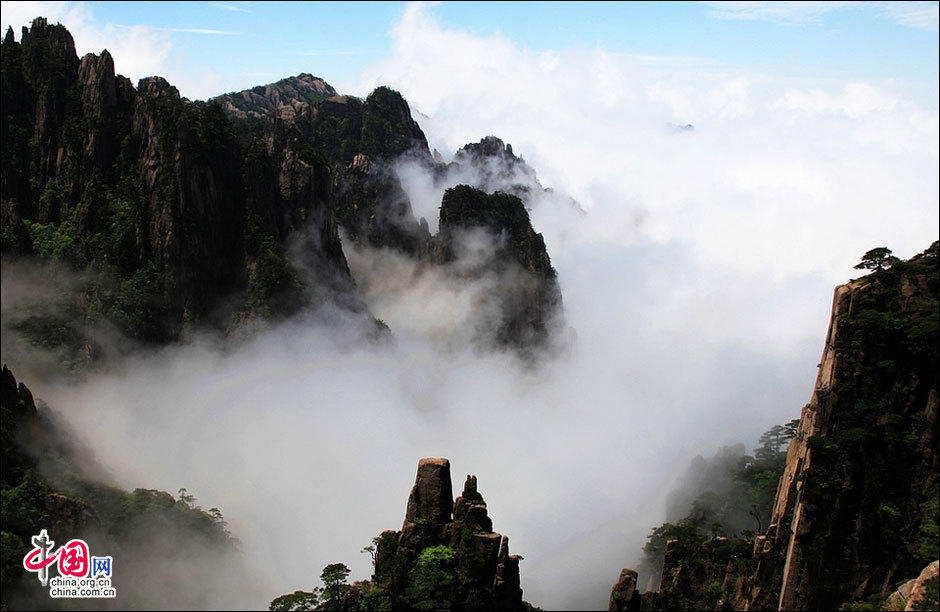 Huangshan Mountain, listed as a UNESCO cultural and natural heritage and World Geopark, boasts of spectacular landscapes thick with vegetation and lofty peaks. The 154-square-kilometer sight-seeing area possesses four unique scenes: peculiarly shaped granite rocks, waterfalls, pine trees and views of the clouds from above. The Flying over Rock, the Stone Monkey Gazing over the Sea of Clouds, the Brush pen-liked Rock and many other renowned scenic spots attract streams of visitors to the marvelous mountain every day. (China.org.cn)