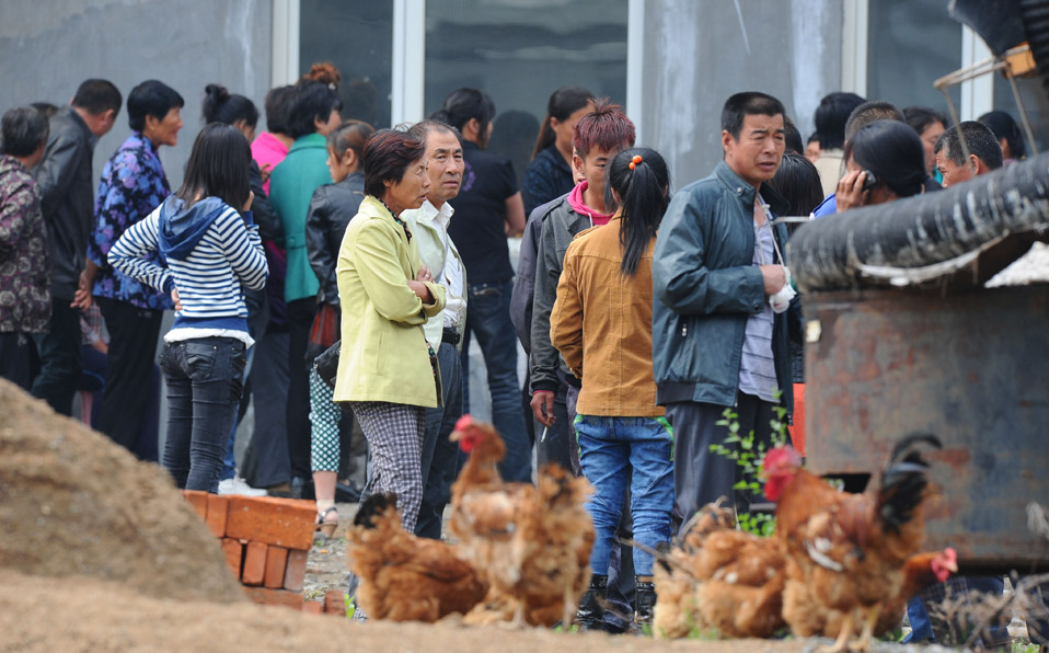 People wait outside the plant for information after a fire occurred in a slaughterhouse 