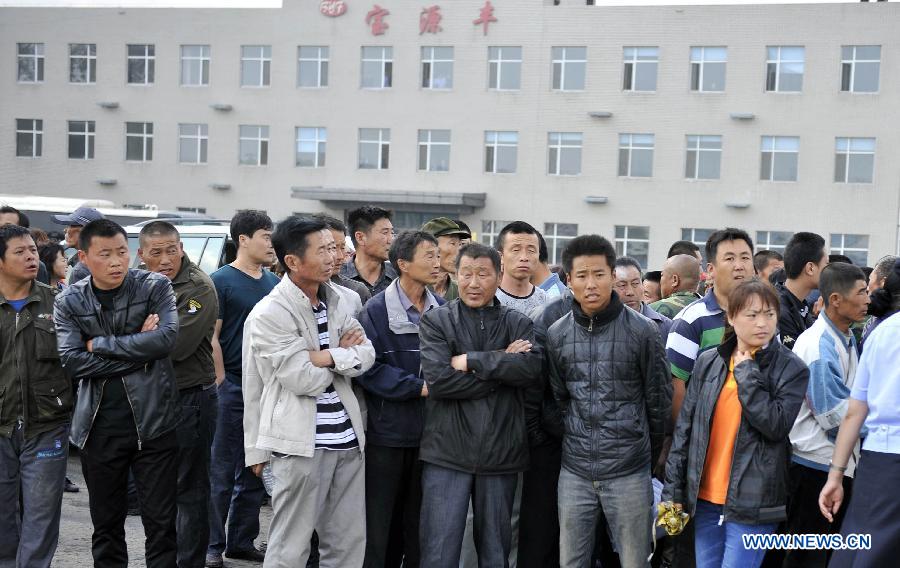 Family members of workers and local residents wait for information at the accident site after a fire occurred in a slaughterhouse owned by the Jilin Baoyuanfeng Poultry Company in Mishazi Township of Dehui City, northeast China's Jilin Province, June 3, 2013. Death toll from the poultry processing plant fire on Monday morning has risen to 119. (Xinhua/Wang Haofei)