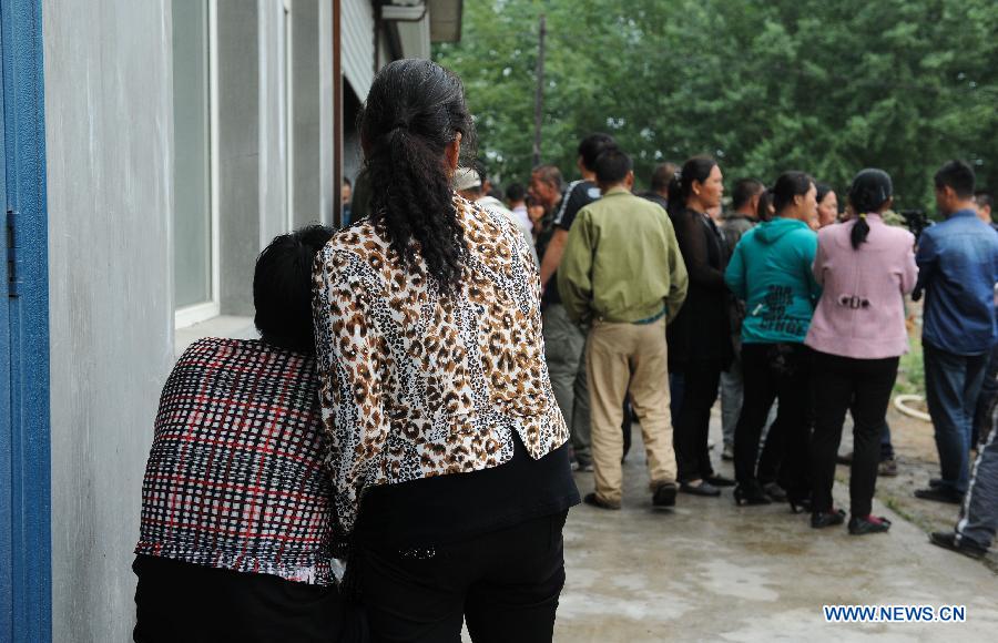 Family members of missing workers wait for information after a fire occurred in a slaughterhouse owned by the Jilin Baoyuanfeng Poultry Company in Mishazi Township of Dehui City, northeast China's Jilin Province, June 3, 2013. Death toll from the poultry processing plant fire on Monday morning has risen to 119. Over 300 workers were in the plant when the accident happened. (Xinhua/Xu Chang)