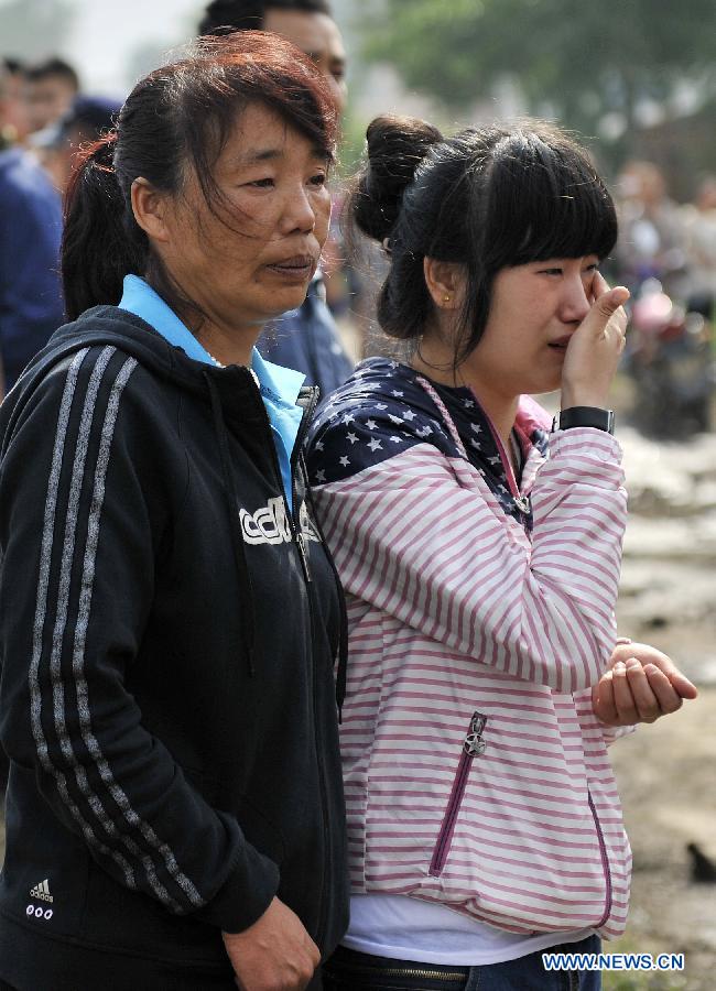 Family members of workers cry as waiting for information after a fire occurred in a slaughterhouse owned by the Jilin Baoyuanfeng Poultry Company in Mishazi Township of Dehui City, northeast China's Jilin Province, June 3, 2013. Death toll from the poultry processing plant fire on Monday morning has risen to 119. (Xinhua/Wang Haofei)
