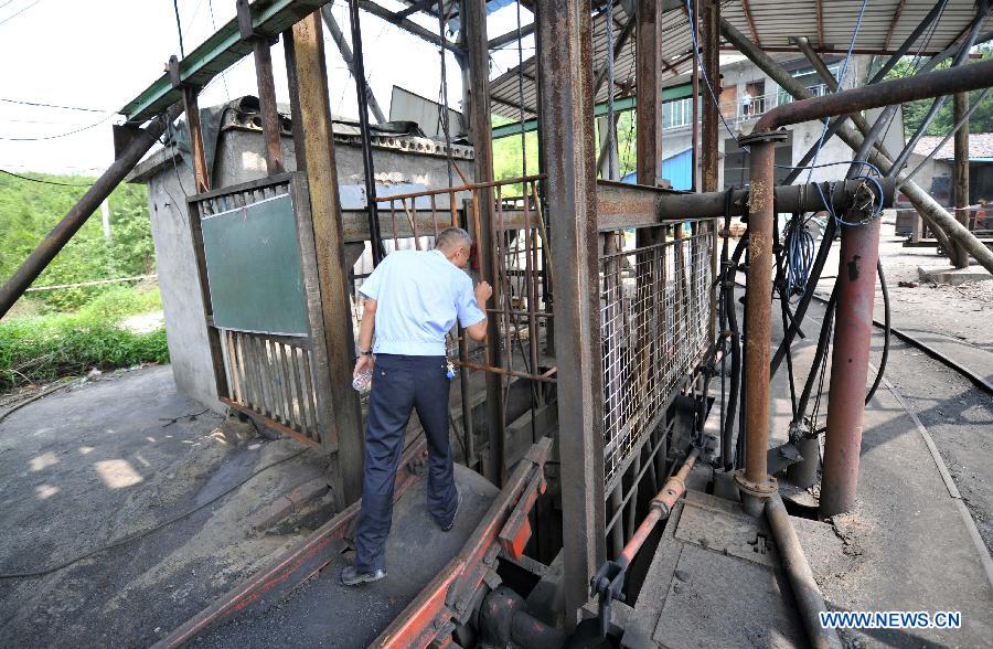 Photo taken on June 3, 2013 shows a man looking into the shaft of Simachong coal mine where a colliery gas explosion happened in Shaodong County, central China's Hunan Province. Ten people have been confirmed dead after a colliery gas explosion occurred on Sunday at Simachong coal mine, local authorities said on Monday. (Xinhua/Li Ga)