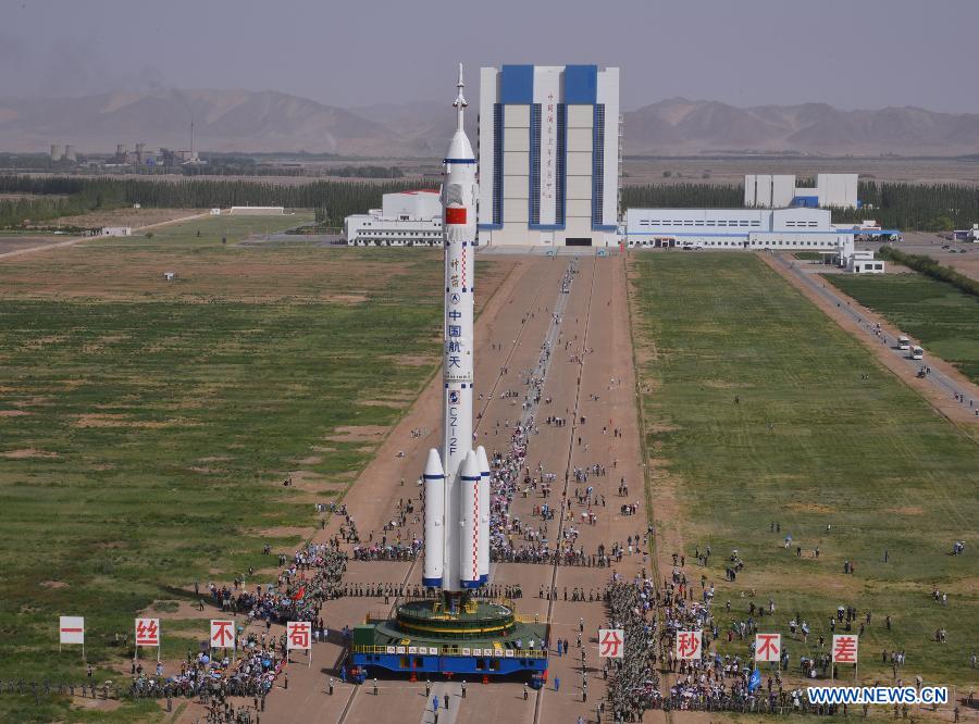 Photo taken on June 3, 2013 shows the assembly of the Shenzhou-10 spacecraft and the Long March-2F carrier rocket at Jiuquan Satellite Launch Center in Jiuquan, northwest China's Gansu Province. The assembly was transported to the launch site on Monday morning, which marks the manned Shenzhou-10 mission entering the final phase of its preparation. The spacecraft, which will be launched in mid-June from the Jiuquan Satellite Launch Center, will carry three astronauts and dock with Tiangong-1, target orbiter and space module. (Xinhua/Liang Jie)