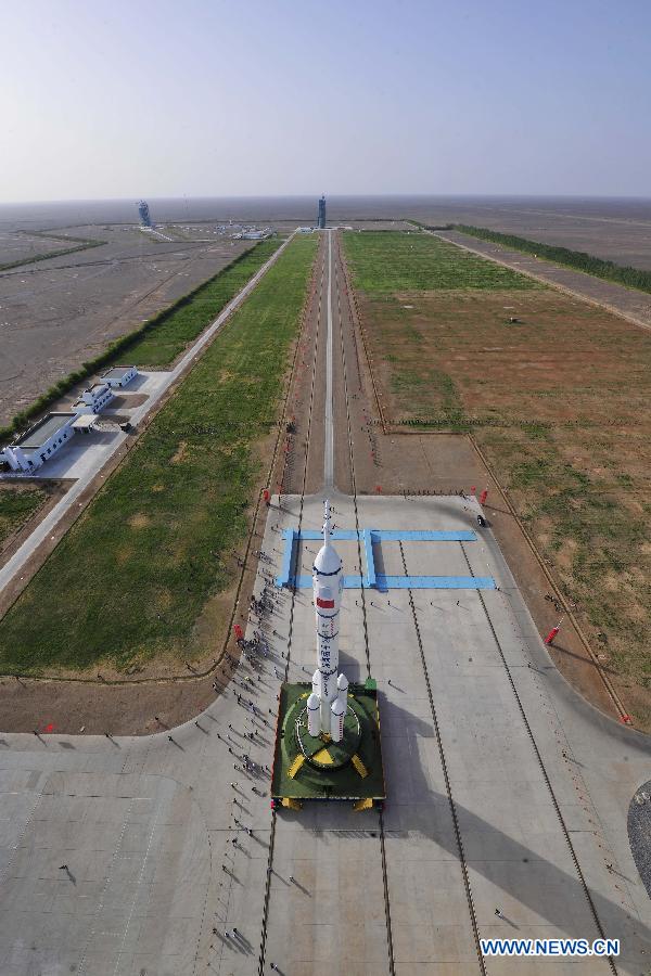 Photo taken on June 3, 2013 shows the assembly of the Shenzhou-10 spacecraft and the Long March-2F carrier rocket at Jiuquan Satellite Launch Center in Jiuquan, northwest China's Gansu Province. The assembly was transported to the launch site on Monday morning, which marks the manned Shenzhou-10 mission entering the final phase of its preparation. The spacecraft, which will be launched in mid-June from the Jiuquan Satellite Launch Center, will carry three astronauts and dock with Tiangong-1, target orbiter and space module. (Xinhua/Liang Jie)