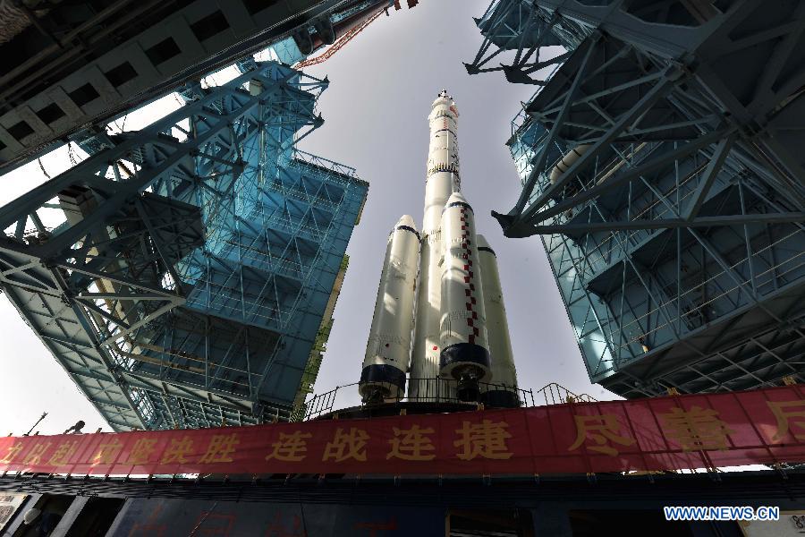 Photo taken on June 3, 2013 shows the assembly of the Shenzhou-10 spacecraft and the Long March-2F carrier rocket at Jiuquan Satellite Launch Center in Jiuquan, northwest China's Gansu Province. The assembly was transported to the launch site on Monday morning, which marks the manned Shenzhou-10 mission entering the final phase of its preparation. The spacecraft, which will be launched in mid-June from the Jiuquan Satellite Launch Center, will carry three astronauts and dock with Tiangong-1, target orbiter and space module. (Xinhua/Liang Jie)