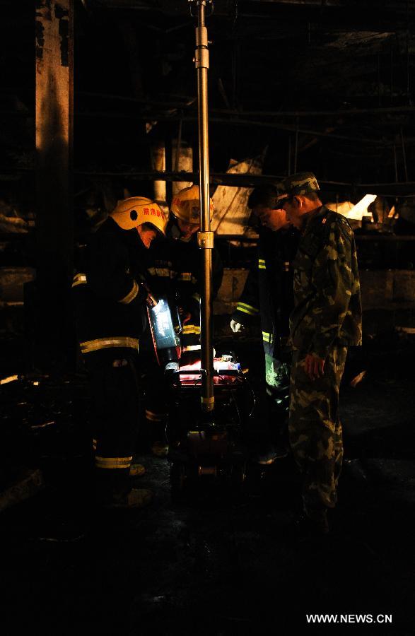 Firemen refill gas for a spotlight at the burnt poultry slaughterhouse owned by the Jilin Baoyuanfeng Poultry Company in Mishazi Township of Dehui City in northeast China's Jilin Province, June 3, 2013. The death toll from the fire has risen to 119 as of 8 p.m. on Monday. Search and rescue work is under way. (Xinhua/Xu Chang)