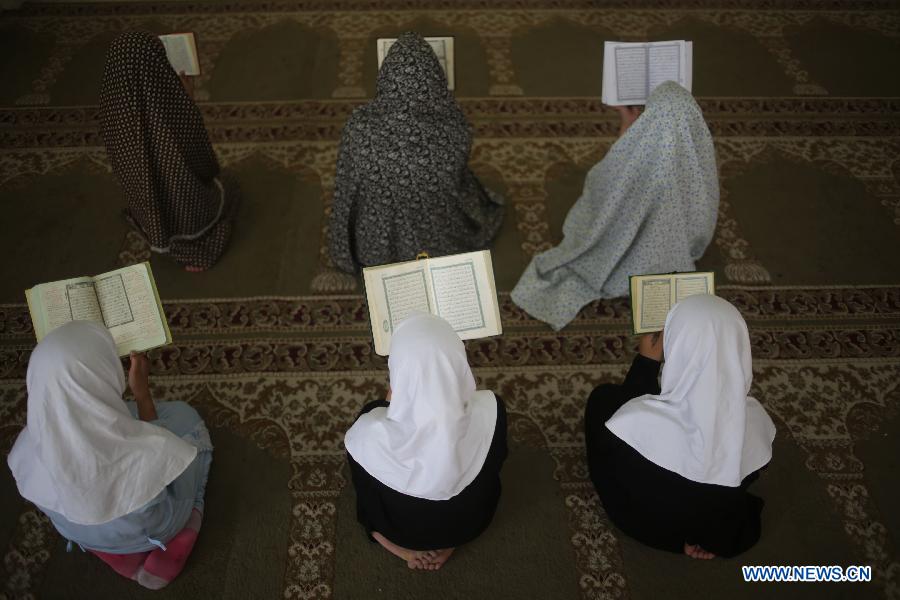 Palestinian girls read Muslim holy book Quran during a lesson at a mosque in Gaza City, on June 3, 2013. (Xinhua/Wissam Nassar) 