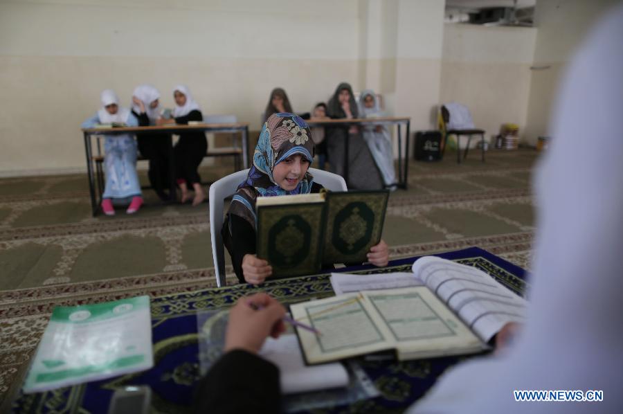 Palestinian girls read Muslim holy book Quran during a lesson at a mosque in Gaza City, on June 3, 2013. (Xinhua/Wissam Nassar) 