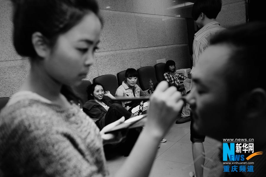 Tang Ling help the actors make up. This is her part-time job in the club; she also serves as stage manager. “Make up is a creative job and I enjoy it.” she loves it. (Photo/Xinhua)