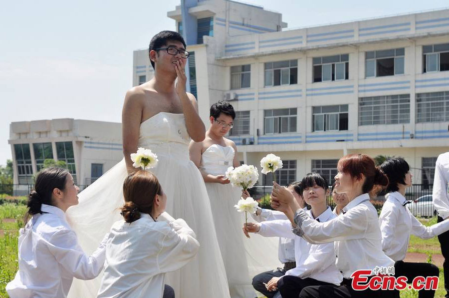 Boys wearing wedding dresses pose for graduation group photos at Hunan University of Arts and Science in Changde, central China's Hunan Province. [CNS Photo/Jia Siyuan]