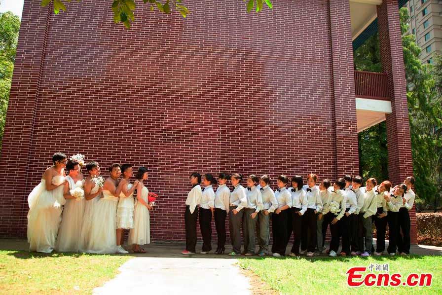Boys wearing wedding dresses and girls in men's suits pose for graduation group photos at Hunan University of Arts and Science in Changde, central China's Hunan Province. [CNS Photo/Jia Siyuan]