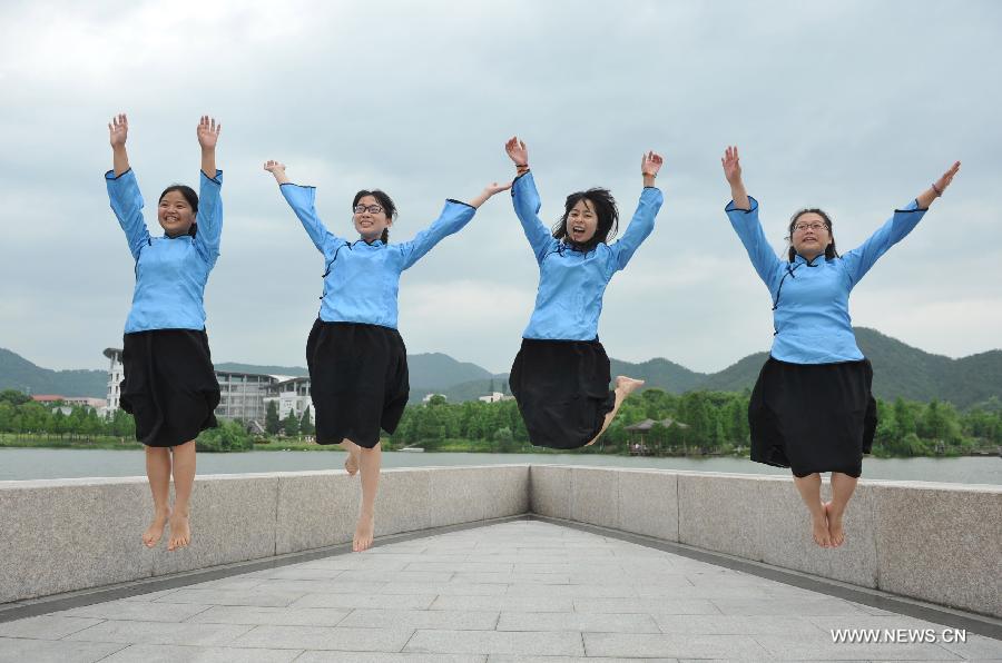 Graduates pose for photos at Zhejiang Agriculture and Farming University in Hangzhou, capital of east China's Zhejiang Province, May 26, 2013. (Xinhua/Hu Jianhuan) 