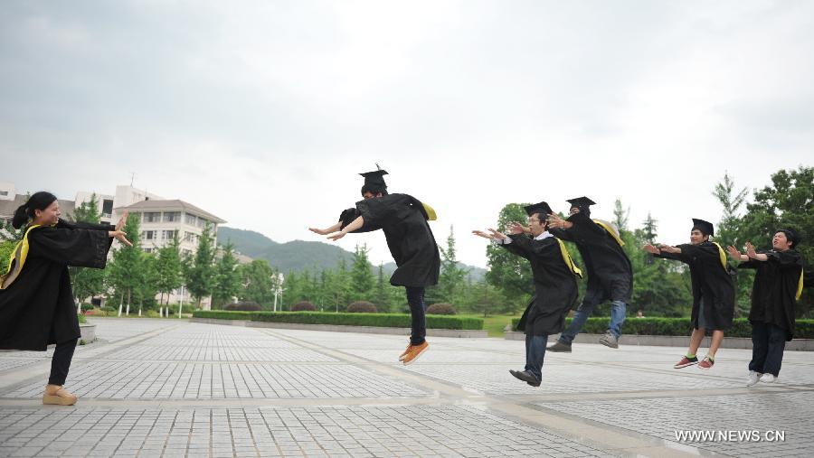 Graduates wearing academic dresses pose for photos at Zhejiang Agriculture and Farming University in Hangzhou, capital of east China's Zhejiang Province, May 26, 2013. (Xinhua/Hu Jianhuan) 