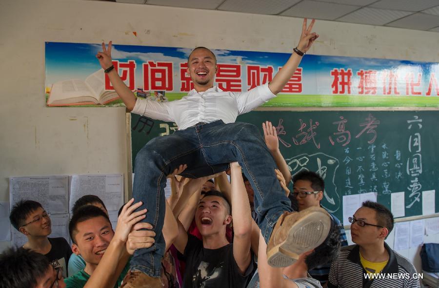 Students raise their teacher He Xueyi to express gratitudes on the occasion of their graduation at the Yucai Middle School in Chongqing, southwest China, June 4, 2013. Three days later, the high school graduates will take part in the national college entrance exam, which is set for June 7 and 8. (Xinhua/Chen Cheng) 