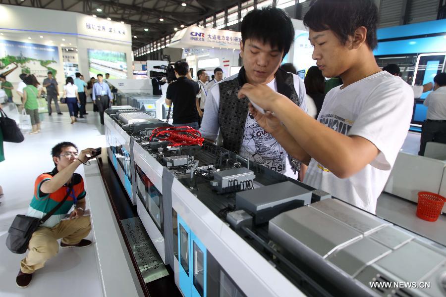 Visitors take photos for a light rail vehicle at the 8th Rail and Metro China exhibition held in Shanghai, east China, June 4, 2013. The exhibition, opened here on Tuesday, has attracted over 180 exhibitors from 12 countries and regions. (Xinhua/Liu Changlong) 