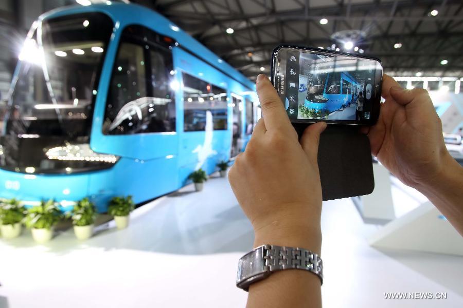A visitor takes pictures for a tramcar at the 8th Rail and Metro China exhibition held in Shanghai, east China, June 4, 2013. The exhibition, opened here on Tuesday, has attracted over 180 exhibitors from 12 countries and regions. (Xinhua/Liu Changlong) 