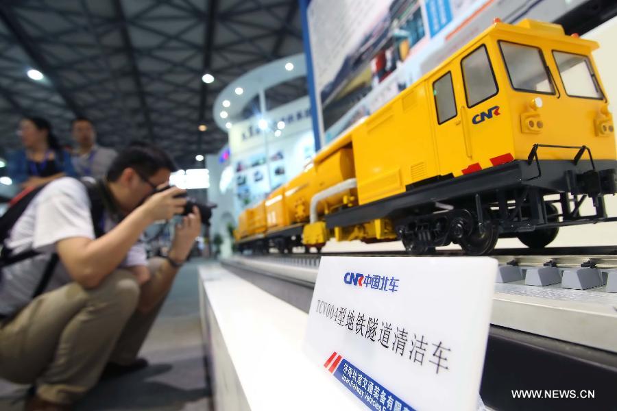 A visitor takes pictures for a tunnel cleaner model at the 8th Rail and Metro China exhibition held in Shanghai, east China, June 4, 2013. The exhibition, opened here on Tuesday, has attracted over 180 exhibitors from 12 countries and regions. (Xinhua/Liu Changlong)