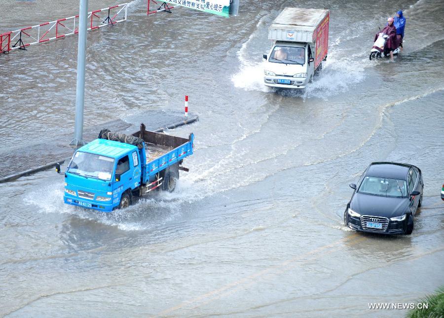 Vehicles run in floods in Nanning City, south China's Guangxi Zhuang Autonomous Region, June 4, 2013. A heavy rainfall hit Nanning on Tuesday, and local meteorological authorities issued an orange alert for rainstorms. China has a four-color warning system for strong rain, with red being the most serious, followed by orange, yellow and blue. (Xinhua/Zhou Hu)