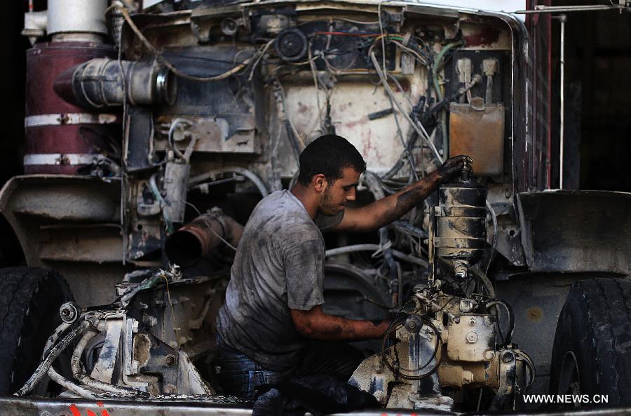 A Palestinian boy works at a garage for repairing cars in Gaza city on June 4, 2013. Many boys left school to work in many different jobs to support their families. Child labor is widespread in the Gaza Strip because of the high rates of poverty. (Xinhua/Yasser Qudih) 