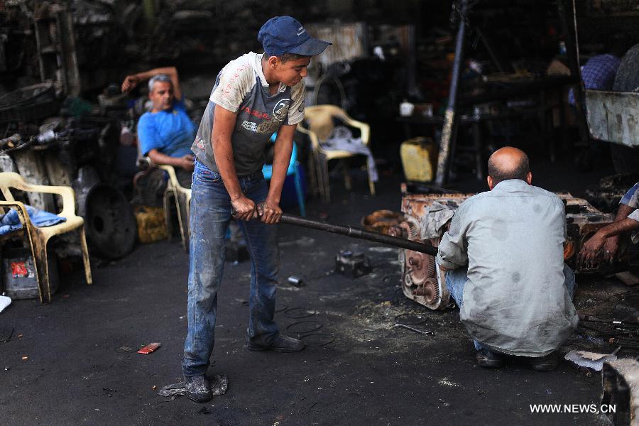 Palestinian boys work at a garage for repairing cars in Gaza city on June 4, 2013. Many boys left school to work in many different jobs to support their families. Child labor is widespread in the Gaza Strip because of the high rates of poverty. (Xinhua/Yasser Qudih) 