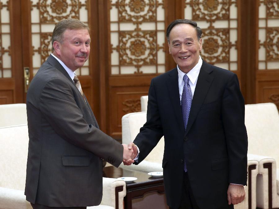 Wang Qishan (R), a member of the Standing Committee of the Political Bureau of the Communist Party of China (CPC) Central Committee, meets with Andrei Kobyakov, head of the Belarusian presidential administration, in Beijing, capital of China, June 4, 2013. (Xinhua/Pang Xinglei)