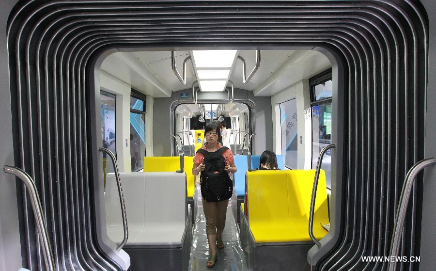 A visitor walks in a tramcar displayed on the exhibition "Rail + Metro China 2013" in Shanghai, east China, June 4, 2013. The exhibition, showcasing metro and rail-related technologies and products worldwide, kicked off here Tuesday. (Xinhua/Pei Xin)