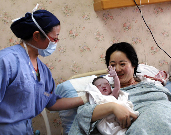Mother Lu (C) holds her new baby boy, who was born in water, at Shanghai Changning Maternity & Infant Health Hospital, on June 3, 2013. 