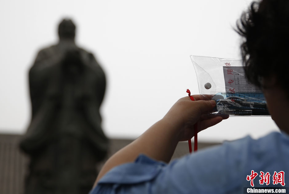 A student’s mother prays in front of the Statue of Confucius with student’s admission sheet of exam in her hand in Confucian temple in Beijing as national college entrance exam (Gaokao) is around the corner. Every year before Gaokao, loads of students accompanied by their parents come and pray at Confucian temple. (CNS/Liu Guanguan)