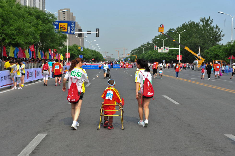 A child participates in the marathon competition with the help of a walking booster in Wuqing, Tianjin Municipality on May 25, 2013. (Xinhua Photo/  Zhai Jianlan)